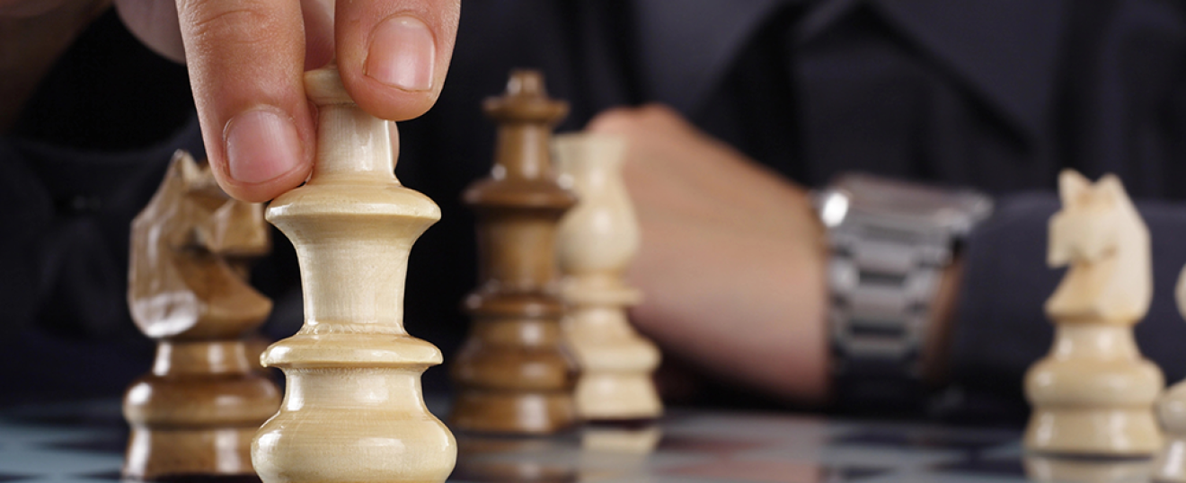 Chess piece being moved on a chessboard, symbolizing strategic financial decision-making.